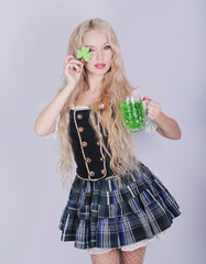 Beautiful woman in dress with a green irish beer. Happy St. Patrick's Day.