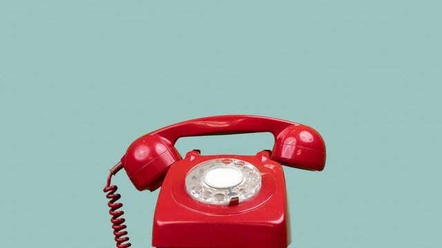 A red classic rotary telephone stop motion