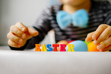 Hand Kid Boy Letters Easter Background Colored Eggs. Postcard. Family Learning to Read. Selective focus.