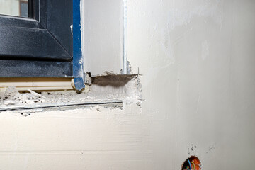 Forged place in the wall under the window, prepared for installing a window sill inside the house.