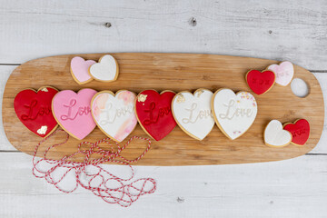 Romantic-themed cookies displayed on a wooden baord