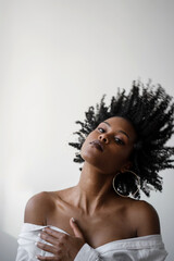 Portrait of a beautiful black woman flicking her curly hair