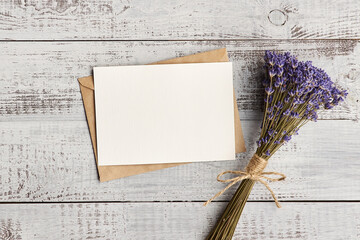 Invitation card with copy space and lavender flowers bunch on wooden background