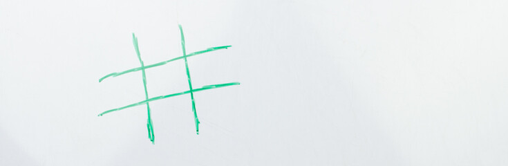 The hashtag symbol is drawn with a green felt-tip pen on a white school board