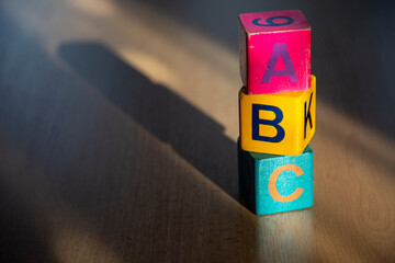 Wooden play cubes with the letters ABC on a wooden surface
