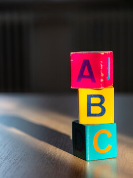 Wooden play cubes with the letters ABC on a wooden surface
