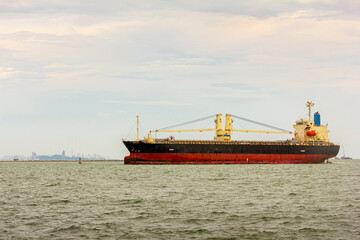 Fototapeta premium Large cargo ship for transportation import export goods sailed in the middle offshore of the sea in evening