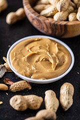 Peanut butter in bowl and peanuts