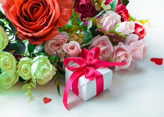 A postcard for Valentine's Day. Roses and a gift in red ribbon on a white background