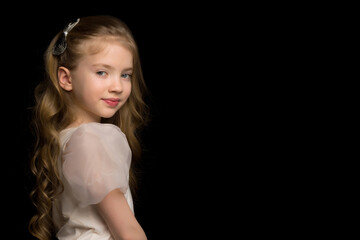 Close-up.Portrait of a cute little girl on a black background.
