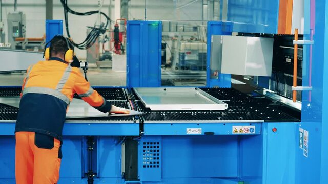 Male engineer is changing aluminum plates on the shearing machine