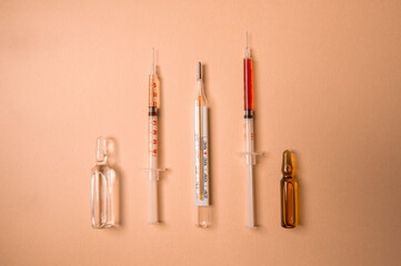 Thermometer, pills and syringes with the vaccine lie on the table surface. Virus treatment. Virus prevention. Healthcare. The medicine. 