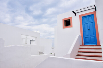 Fototapeta na wymiar Sicilian white houses on Panarea Island, Aeolian Islands. White house with blue and orange door.