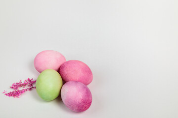Multi-colored eggs with twigs, on a white background with a place for text.