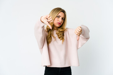Young caucasian blonde woman showing thumb down and expressing dislike.