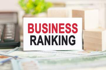 business ranking text on white paper, on the background of bills and wooden blocks, business concept