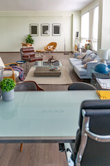 Modern trendy creative design of a personal studio office with a seating area in the style of minimalism in blue and beige colors with large windows and daylight
