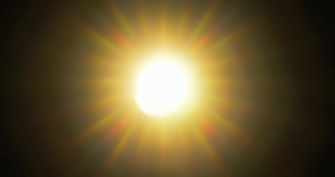 Light rays shining through old camera lens, while diaphragm blades are closing and zooming out