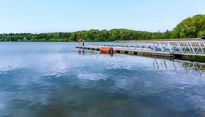 A view out onto the lake past the jetty toward the northern bank of Raventhorpe Water, Northamptonshire, UK