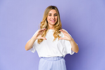 Fototapeta na wymiar Young caucasian blonde woman holding something with palms, offering to camera.