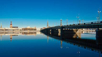 Fototapeta na wymiar riga. in the photo, the stone bridge, in the background, the city against the blue sky