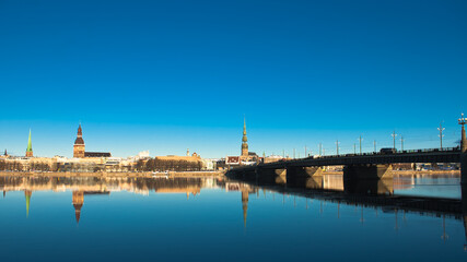 riga. in the photo, a panorama of the city and a stone bridge against the blue sky