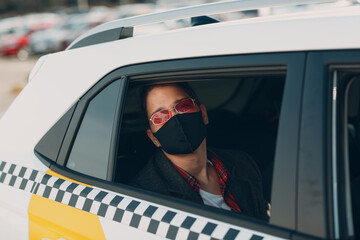 Man passenger in protective face medical mask in the taxi car during an epidemic quarantine city. Health protection, safety and pandemic Covid-19 concept.
