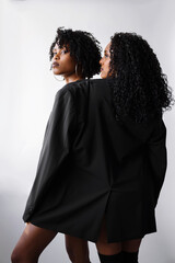 Two beautiful dark skin women wearing same jacket