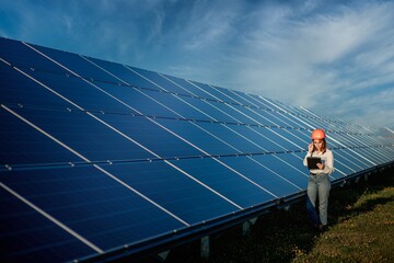 Inspector Engineer Woman Holding Digital Tablet Working in Solar Panels Power Farm, Photovoltaic...