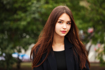 Young beautiful brunette girl in the autumn park