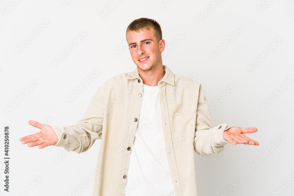 Wall mural young caucasian handsome man makes scale with arms, feels happy and confident.