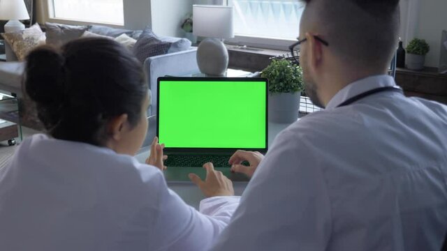 Two medical research scientists looking at green screen in the modern laboratory.