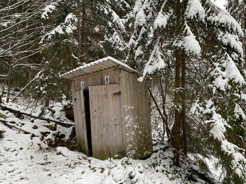 Country toilet in the winter outdoors. Outdoor toilet construction. Cabin - Toilet in the forest on the snow.