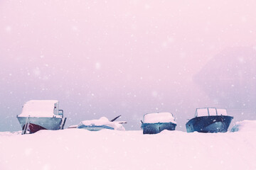 Winter snow covered boats parked on a lake