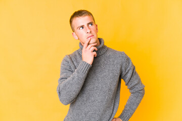 Fototapeta premium Young caucasian handsome man looking sideways with doubtful and skeptical expression.
