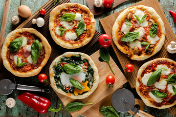 Whole fresh pizzas with green basil, tomatoes, mushrooms and egg