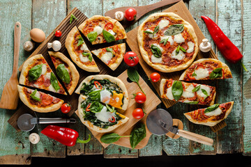 Five cutted pizzas overhead view