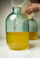 The process of making limoncello lemon liqueur at home. A man mixes lemon zest alcohol with sugar...