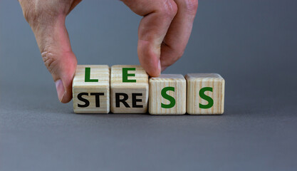 Having less stress or being stress-less. Businessman turns wooden cubes and changes the word...