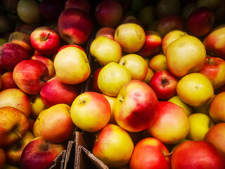 Naklejka na ściany i meble many red ripe apples lie on a shelf in a box in a supermarket