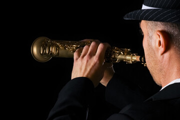 soprano saxophone in the hands of a guy on a black background