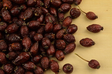 Rose hips, dried wild rose fruits onnatural wooden background, super food, healthy fruits, vitamin C and antioxidants resource