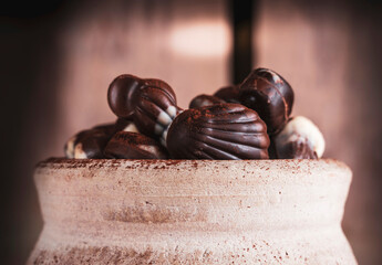 shell shaped chocolates with cream in a clay jar