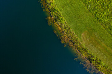 Top Down Aerial View Of Water Meeting Grassland 