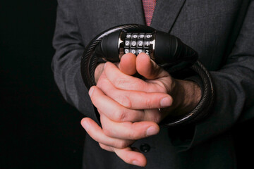 Hands wrapped with metal steel safe lock with numbers 2021. Lock down concept. Effect of COVID 19 on people life and business concept. Dark background. Selective focus