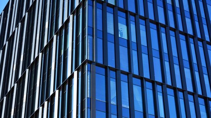 Glass facade of the buildings with a blue sky. Skyscrapers in the business city center.. Background of modern glass buildings. 