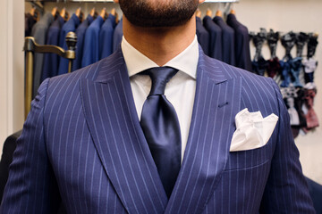 Man in blue pinstripe suit in tailors boutique