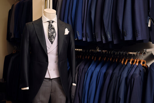 Tailcoat with&not;&dagger;formal striped trousers&not;&dagger;on mannequin and blazers on rack in tailors boutique