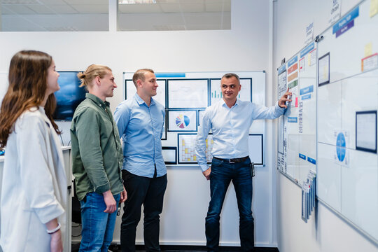 Business people planning while standing in meeting at office