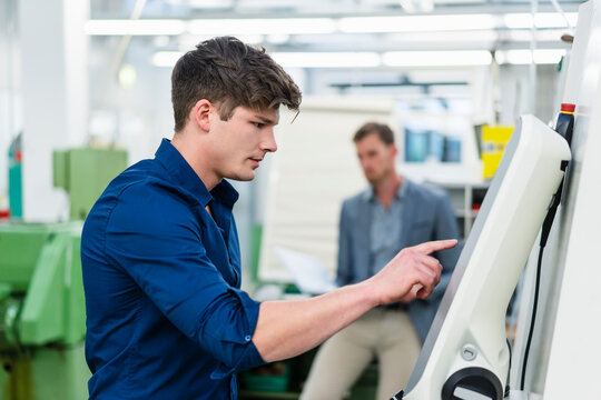 Male engineer operating machinery equipment while working in factory